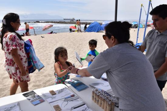 Niños se acercan a la lectura en la playa